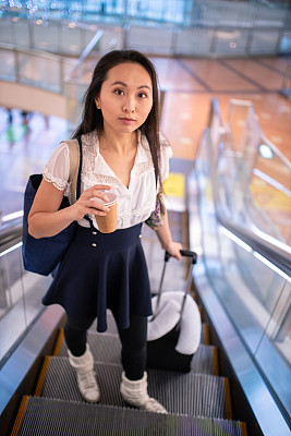 年轻的亚洲女子要去机场登机口