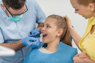牙科医生在牙科诊所检查病人的牙齿