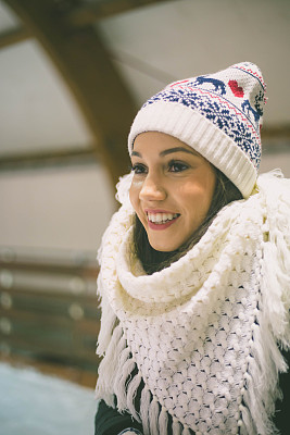 年轻漂亮的女人戴着暖和的冬天的帽子和围巾
