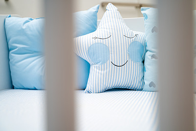 可爱的婴儿床与蓝色枕头星形