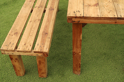 现代现代的壁画餐厅木桌的形象，椅子/长凳设置在人造草作为装饰座位，在阳光明媚的夏季花园铺设露台灰色混凝土广场板，绿色人造草皮人造草坪/草坪草
