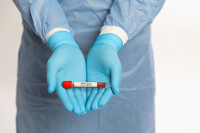 医生在白色背景的试管中拿着阳性冠状病毒样本