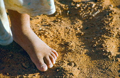 阿尔及利亚撒哈拉难民营沙漠中的一个赤脚孩子的脚