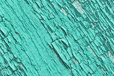 木质背景上蓝色油漆的裂缝。旧剥落的墙面纹理。Emerald-colored树皮。