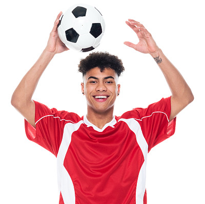 z一代年轻男性运动员穿着足球制服站在白色背景前，手持足球进行足球运动和使用运动球