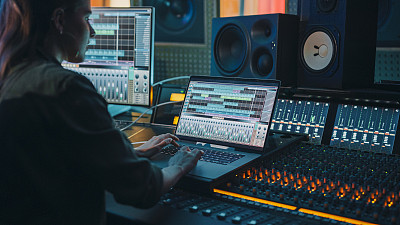 现代音乐唱片工作室控制台与笔记本电脑屏幕显示用户界面的数字音频工作站软件。均衡器，混合器和专业设备。投篮,”滑块。记录。特写镜头