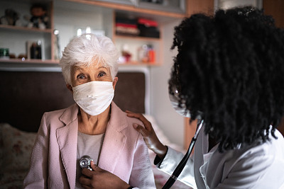病人-老年妇女和健康访视员在家访期间的肖像
