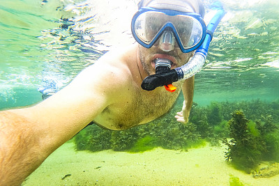 夏天，在法国布列塔尼海岸的浅水里浮潜的人