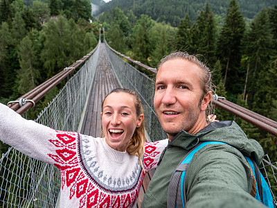 一对夫妇在横跨瑞士松树谷的吊桥上自拍