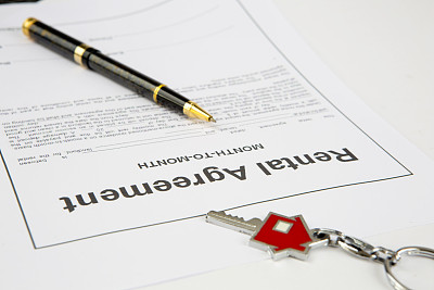 租赁协议文件，有新房子钥匙，红色钥匙圈和钢笔。
