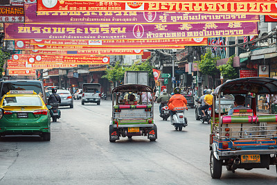10/01/2020曼谷,泰国。“嘟嘟”(机动三轮车)在中国城的街道上迅速地把乘客带到这个地方。传统的人力车比汽车出租车便宜