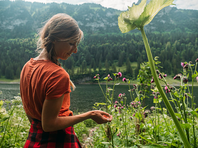 清晨，女人在湖边的野花地里