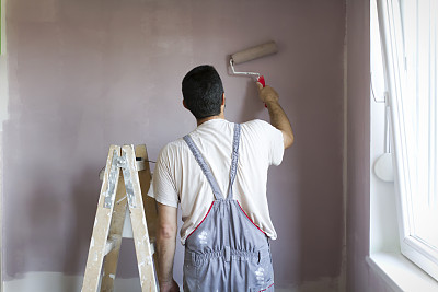 专业油漆工用滚轴在墙上作画
