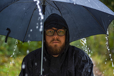 带着雨伞和斗篷穿过树林——被雨淋了