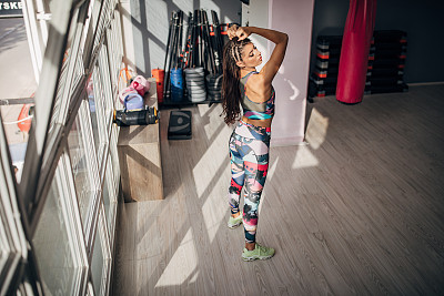 一位年轻的健身女士站在健身房里