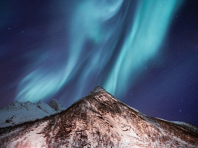 天空背景与北极光。挪威罗浮敦群岛上的北极光。群山之上的北极光。夜晚冬天的风景与极光。挪威的自然背景。