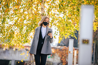一个女商人一边走路一边使用智能手机的肖像