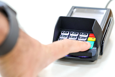 手指在信用卡支付终端点击交易确认。