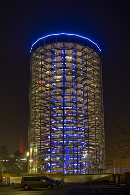 新车停在沃尔夫斯堡大众汽车公司灯火通明的公园塔楼上