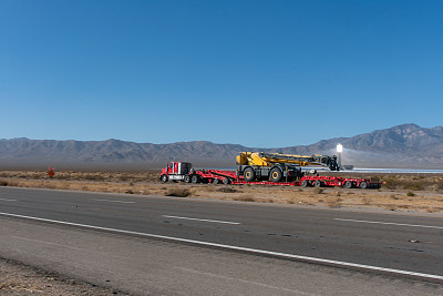 在双向公路上拖着大型牵引车的长途半挂车