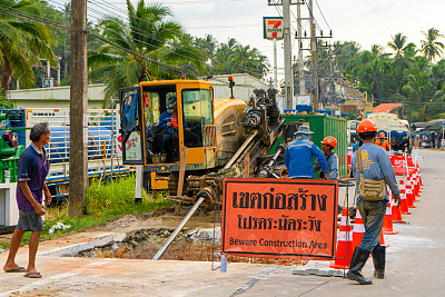 工人们拆除了道路上的一层沥青以铺设管道。在泰国岛上的街道上进行的维修施工工作