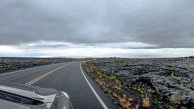 POV沿着汽车行驶在开阔的道路上，熔岩床