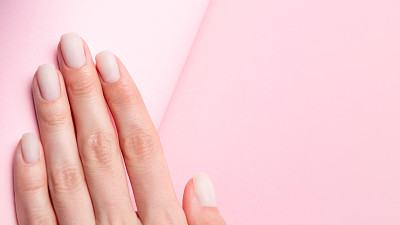 Matt裸指甲接近与复制空间的潮流粉色背景