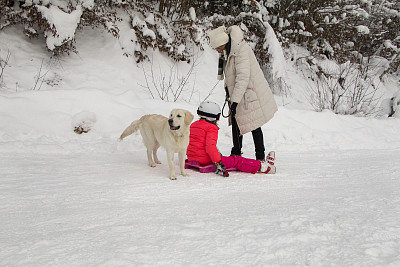 小女孩，一个老妇人和一条狗在享受冬天的一天