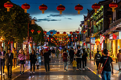 美丽的街景关渡古镇满是人与中国的灯笼和大门在远处在中国云南昆明晚上