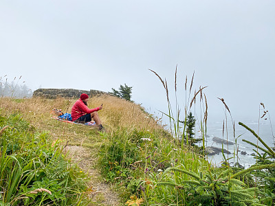 一名徒步旅行者在海边的悬崖上休息