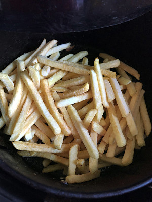 金黄色的，新鲜脆的薯条/薯条在空气炸锅里炸，更健康的零食烹饪选择，高视角
