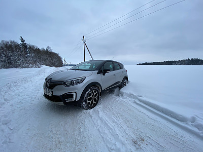 白俄罗斯Grodno -01.31.2021:雷诺Kapture或雷诺俘获SUV在冬日的道路上，背景是田野和森林。雷诺汽车冬日雪地上的驾驶状况