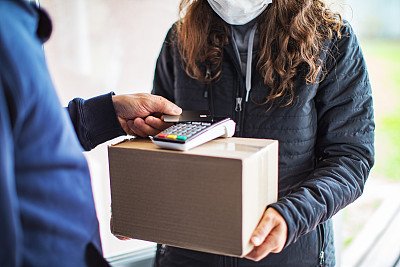 年轻的成年女子收到了快递员寄来的包裹