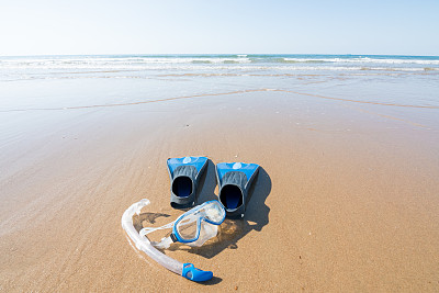 在沙滩上放置潜水和浮潜设备。脚蹼、面罩和通气管。休闲和水上运动概念