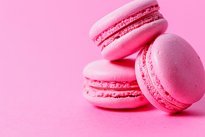 特写一堆粉红色的杏仁饼干，粉红色的馅，粉红色的背景