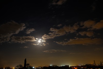 城市灯光在夜晚的照片和满月在天空和云