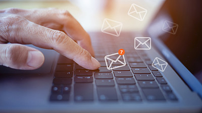 电子邮件营销概念，特写手使用笔记本电脑与电子邮件图标，按摩图标上的虚拟屏幕。