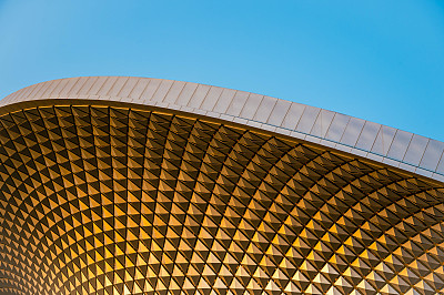 金色屋顶，蓝色日落，日出的天空背景，令人惊叹的独特质感。金属钻石形状的墙壁，反射阳光，金色的时间蓝色小时。