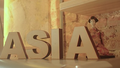亚洲这个词是由木制字母组成的。有一个小雕像的背景。