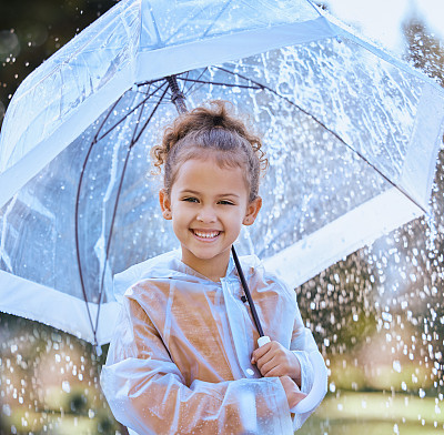 一个小女孩拿着伞在雨中嬉戏