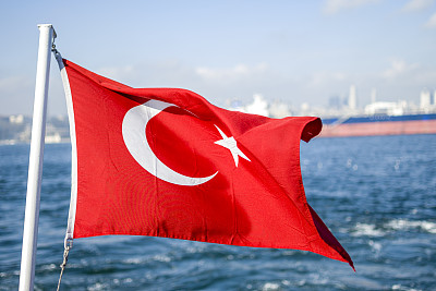 土耳其国旗迎风飘扬，衬着白色的蓝天