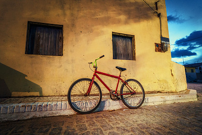 红色的自行车停在巴西乡村街道的拐角处