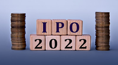 首次公开募股(IPO) 2022 -首字母缩略词在木制立方体上的浅色背景与硬币