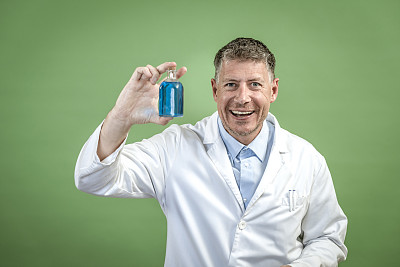 穿着白大褂的科学家，手里拿着一个装着蓝色液体的小烧瓶