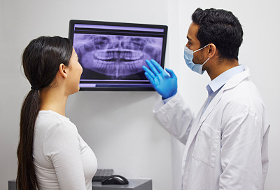 一名牙医讨论病人的牙齿x光检查结果的镜头