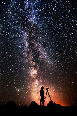 男人的剪影在黑暗的背景。摄影师拍摄的风景。相机三脚架。夏天的星空。星星在天空。美丽的夜晚景观。长时间的曝光。银河系。摘要深空 男人的剪影在黑暗的背景。摄影师拍摄的风景。相机三脚架。夏天的星空。星星在天空。美丽的夜晚景观。长时间的曝光。银河系。摘要深空