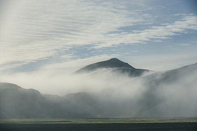 日出时冰岛的陆地上的火山，云层低垂