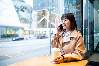 亚洲年轻女子在咖啡店使用智能手机