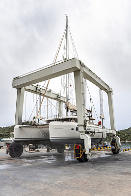 帆船双体船由起重机从干船坞登陆Kaş Marina港进行维修