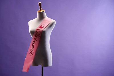 紫色背景的缎带饰带的裁缝人体模特